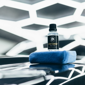 A bottle of Reign on an applicator on a csr bonnet with hex lighting shining on it