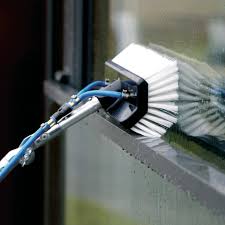 White window cleaning brush with blue pipes on a window with grey frames