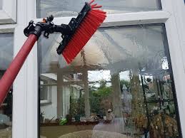Red window cleaning brush cleaning a conservatory window