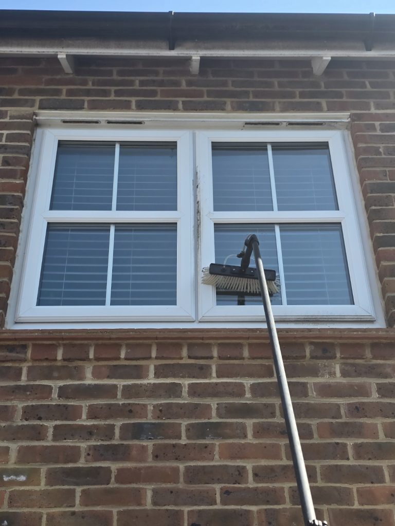 Professional window cleaning using a water-fed pole on upstairs windows